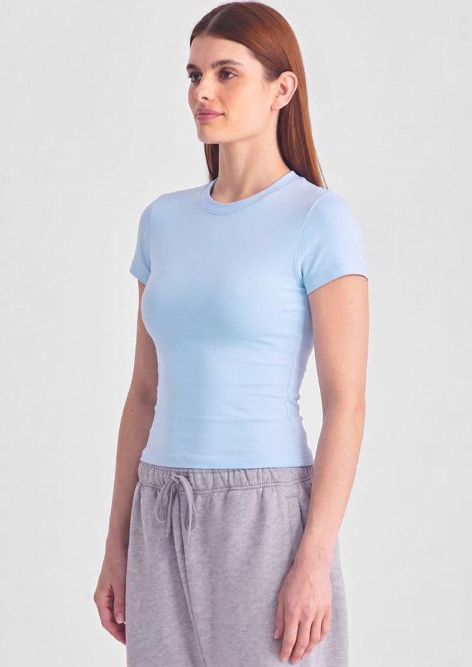 A light blue women's baby tee displayed on a model, featuring a fitted design and short sleeves.
