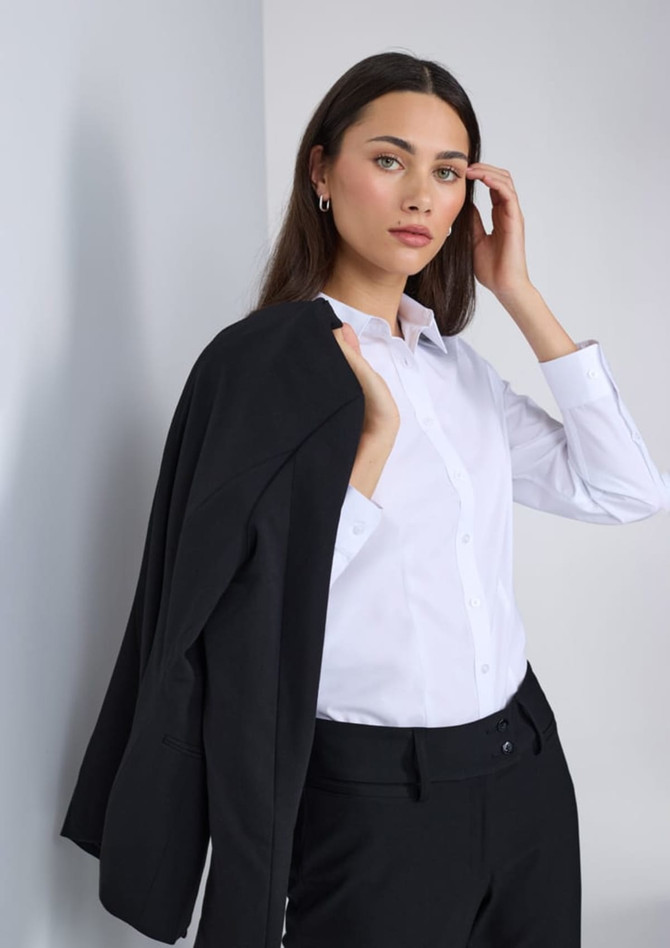 A white long sleeve shirt worn by a model, paired with a black jacket. The model has long, dark hair.