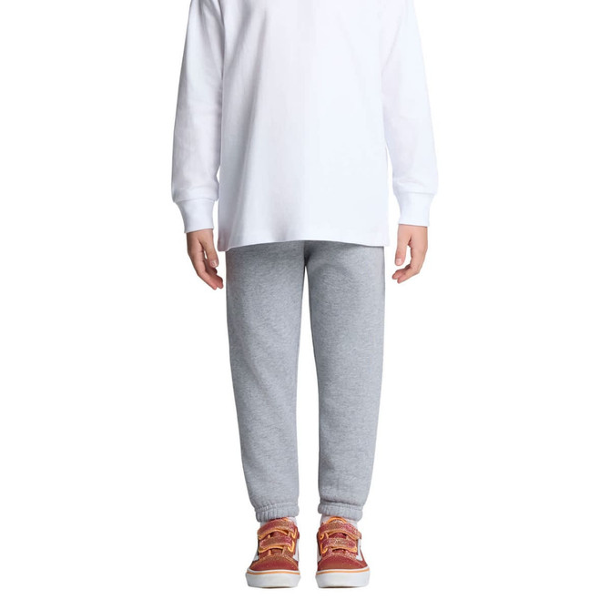 Grey kids' track pants with elastic cuffs, paired with a long-sleeve white top and red shoes. Features a branding logo.