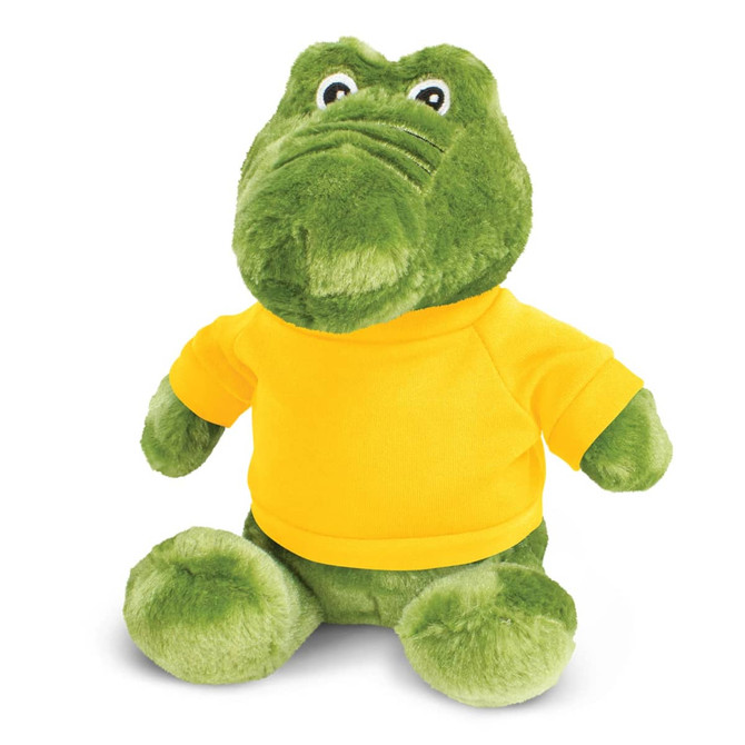 A green crocodile plush toy wearing a yellow shirt, with round eyes and a soft, cuddly appearance.