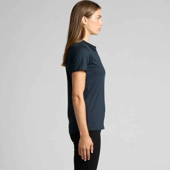 A side view of a woman wearing a dark navy polo shirt, featuring a collar and short sleeves. The shirt has a logo.