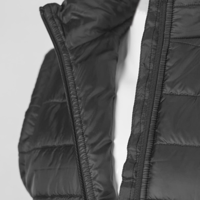 A black unisex puffer vest with a zip, featuring a quilted design and a logo.