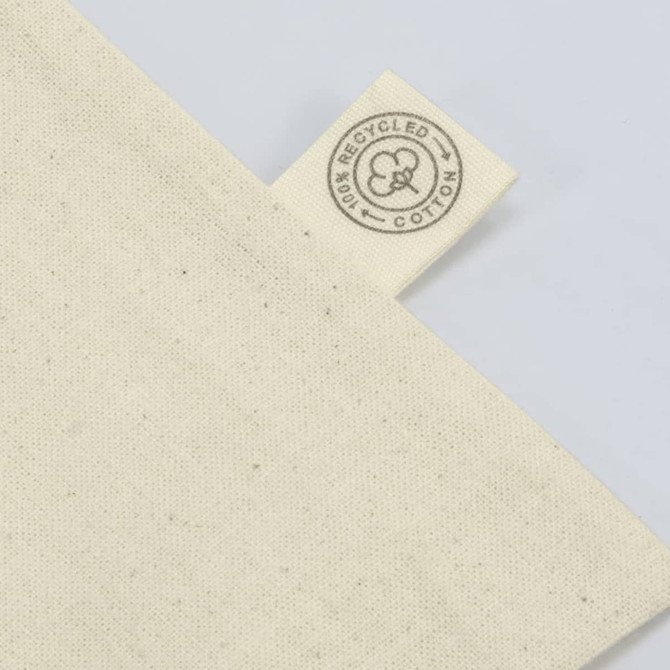 A cream-coloured tote bag made from recycled cotton, featuring a tag with a logo.
