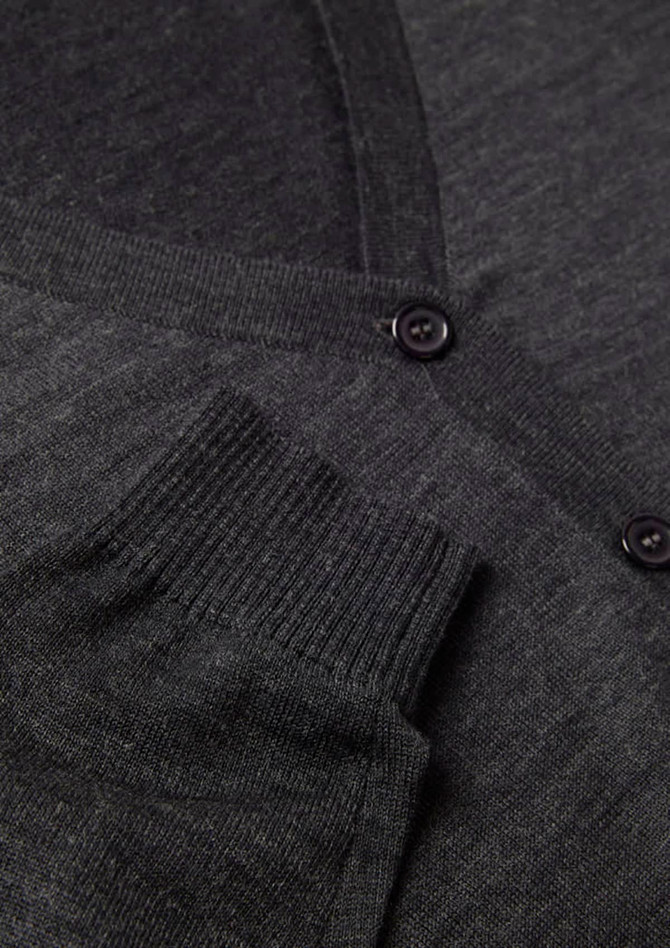 A grey women's button front knit cardigan featuring a pocket and button detail. It includes a logo.