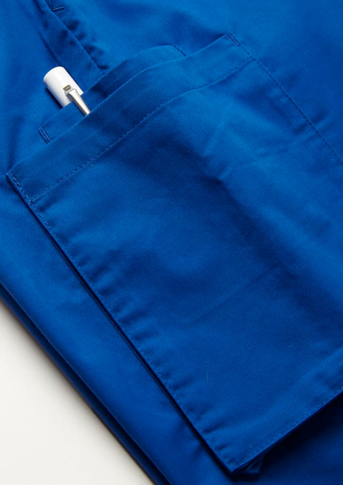 A blue slim leg jogger scrub pant featuring a side pocket with a white pen visible.