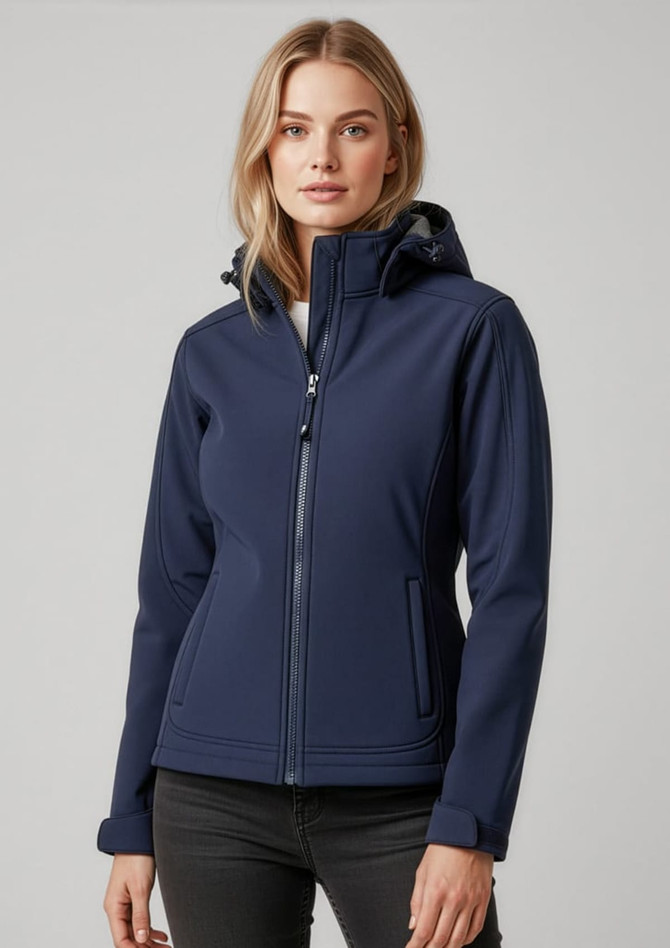 A woman wearing a navy soft shell jacket with a hood, featuring a zip closure and stylish design.