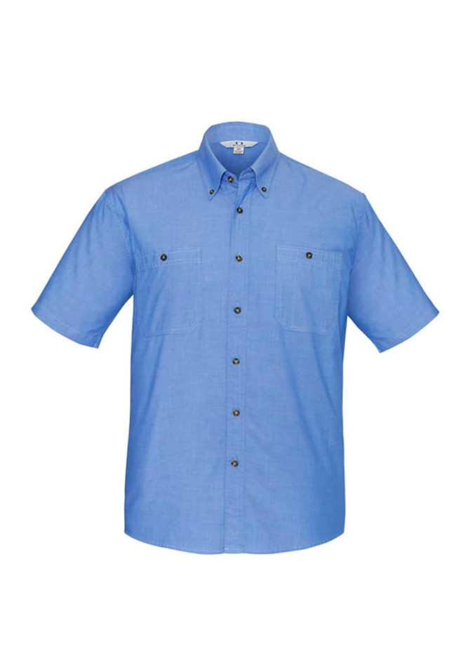 A blue short sleeve chambray button-up shirt featuring two chest pockets and a logo on the collar.