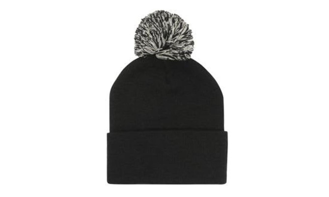 Acrylic beanie in black with a contrasting black and white pom pom on top. It features a rolled cuff.