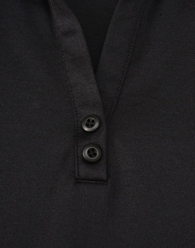 A black polo shirt featuring a textured fabric and two buttons at the neckline. It has a logo on it.