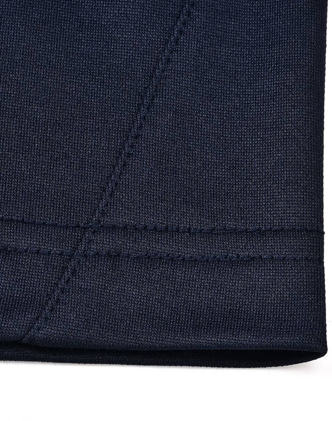 A close-up of the hem of a navy polo shirt showcasing the fabric texture and stitching detail.