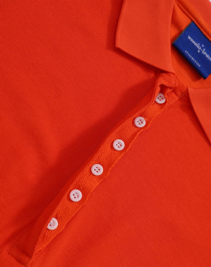 An orange polo shirt with a collar and a button placket. It features a branding label on the inside.