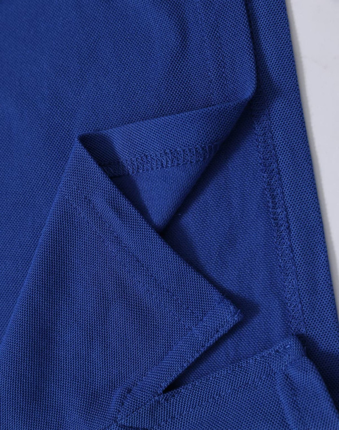 A blue polo shirt featuring a textured fabric with a folded sleeve detail and a branding logo.
