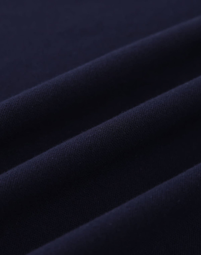 A close-up of navy cotton fabric with visible texture and stretch features, suitable for polo shirts.