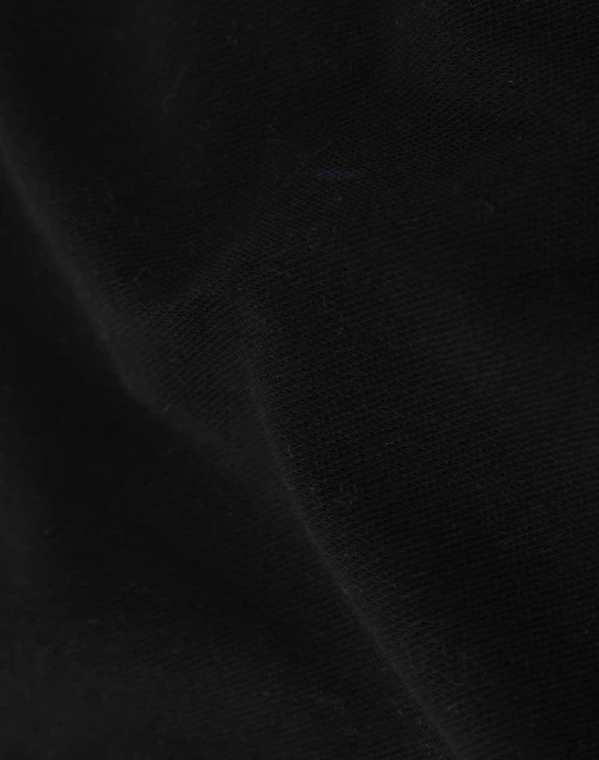 A close-up of black cotton fabric, showcasing its texture and softness suitable for apparel.