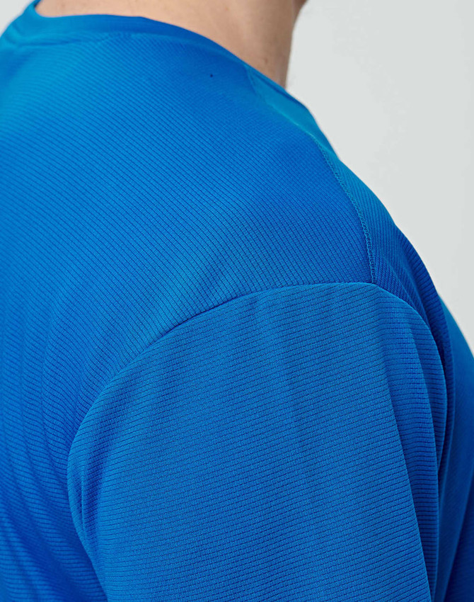A close-up of a men's short-sleeve t-shirt in a vibrant blue colour with a textured fabric. Features a logo.