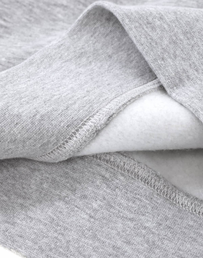 A close-up of a grey crew fleece sweatshirt showing the soft interior fabric and detailed stitching.