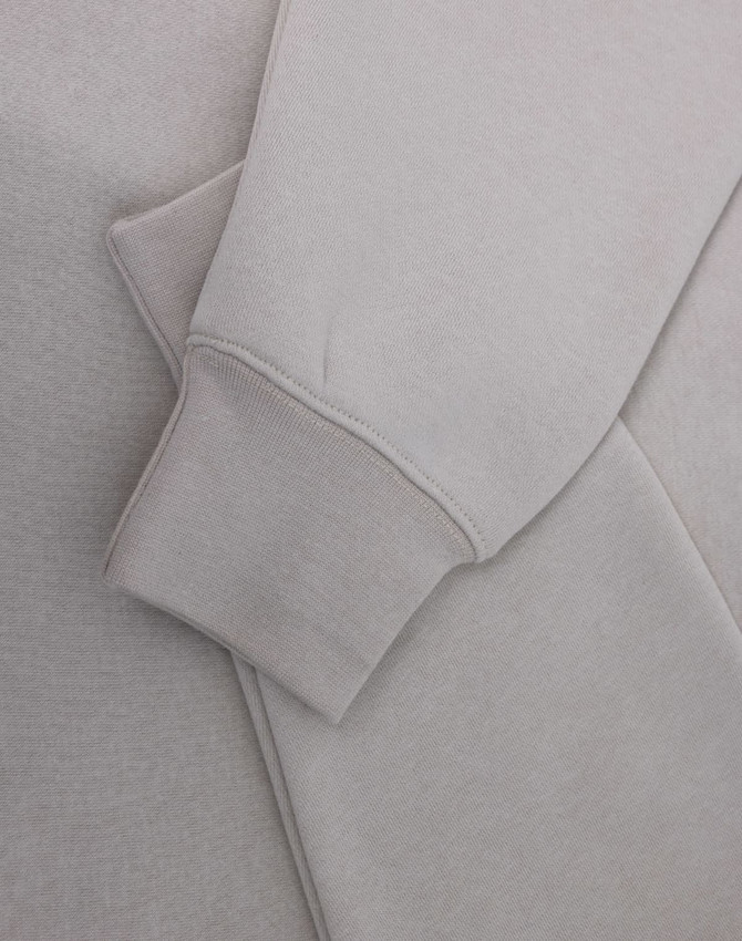 A light grey polar fleece jumper featuring a half zip collar and fitted cuffs. It has a subtle logo.