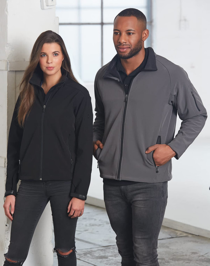 A black and grey softshell jacket worn by a woman and a man, featuring a zip closure and a logo.