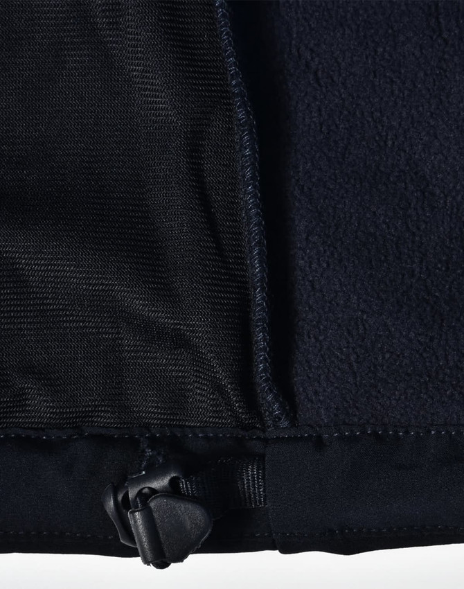 A close-up of a black ladies softshell jacket, highlighting the inner lining and adjustable hem detail.