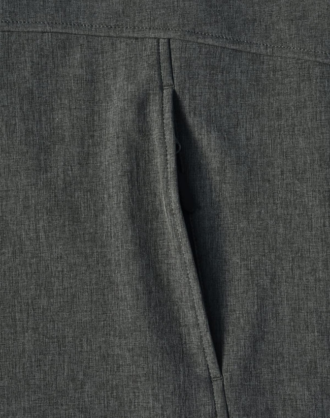 A close-up view of a grey ladies' softshell full zip hoodie showcasing the fabric texture and a zippered pocket.