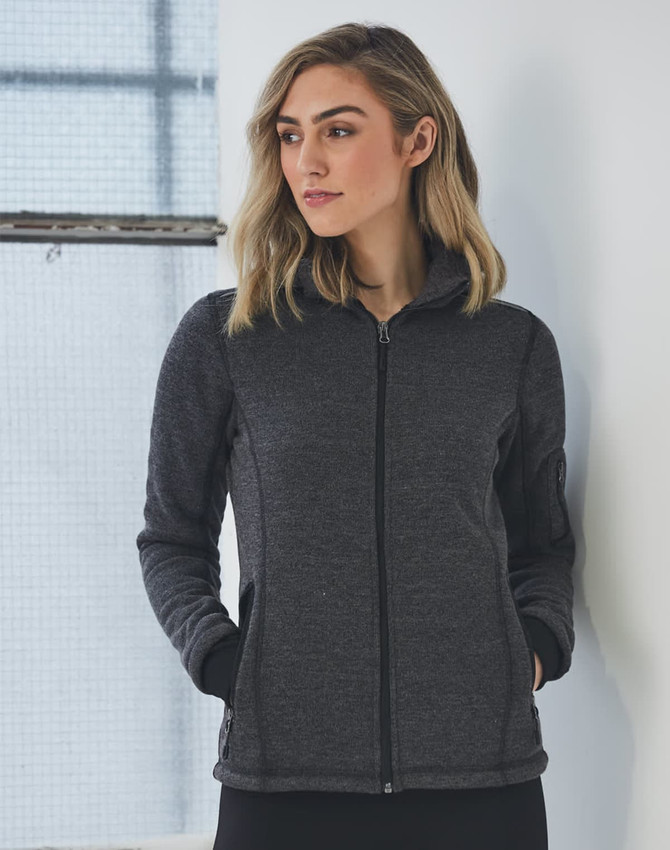 A ladies' heather bonded fleece jacket in dark grey with a zip closure and pockets. The model has a neutral expression.