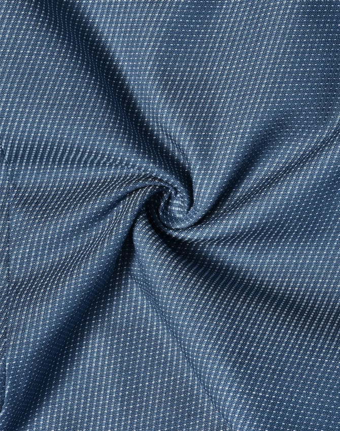 A close-up of a blue fabric with a pin dot pattern, showcasing its stretch and texture.