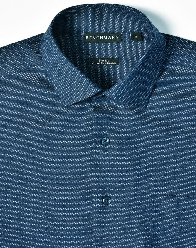 A blue pin dot button-up shirt with a slim fit design, featuring a collar and pocket. It has a branding label.