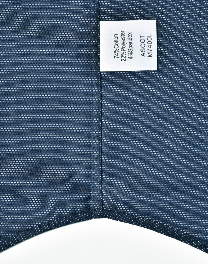 A button-up shirt featuring a pin dot pattern in navy blue, with a care label attached.