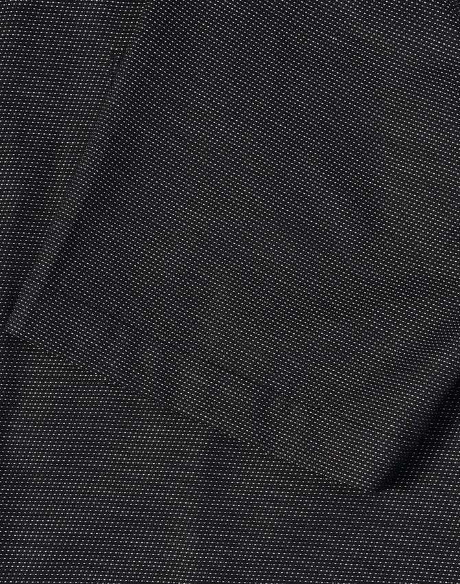 A close-up of a men's black pin dot stretch short-sleeve shirt featuring a pocket and a textured fabric.