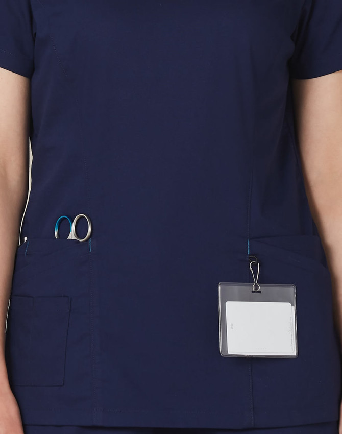 A navy scrub top featuring contrast colour detailing, with pockets for tools and a name badge holder.