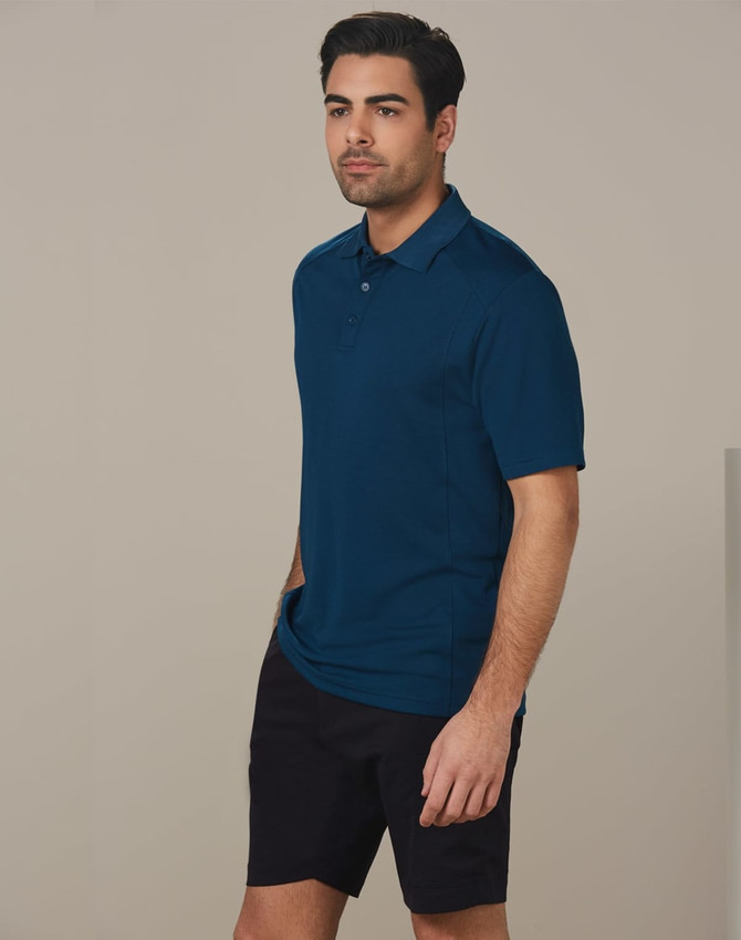 A man wearing a dark teal polo shirt and black cargo shorts, standing against a plain background.
