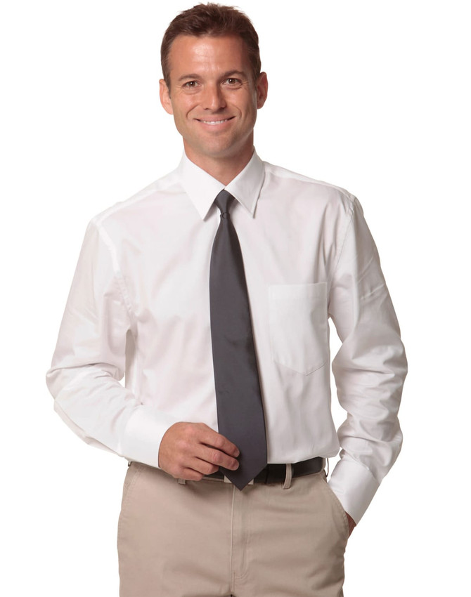 A man wearing a white dress shirt and a grey tie, standing with a friendly smile and beige trousers.