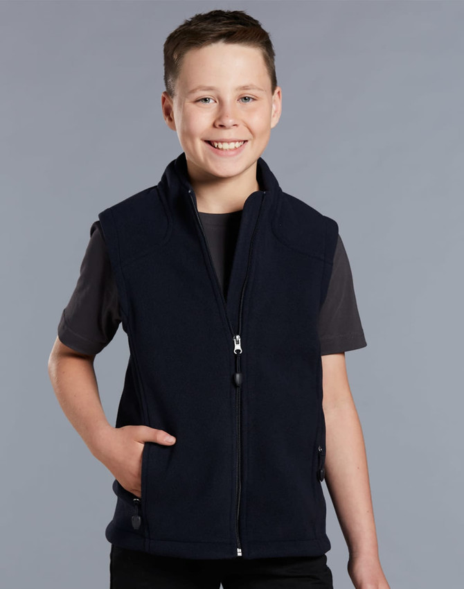 A boy wearing a navy blue fleece vest with a zip and side pockets, smiling against a grey background.