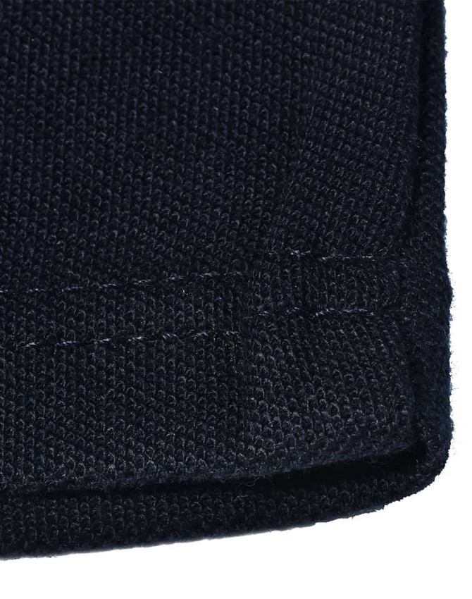 A close-up of a dark navy knit fabric with a hemmed edge, showcasing the texture and stitching details.