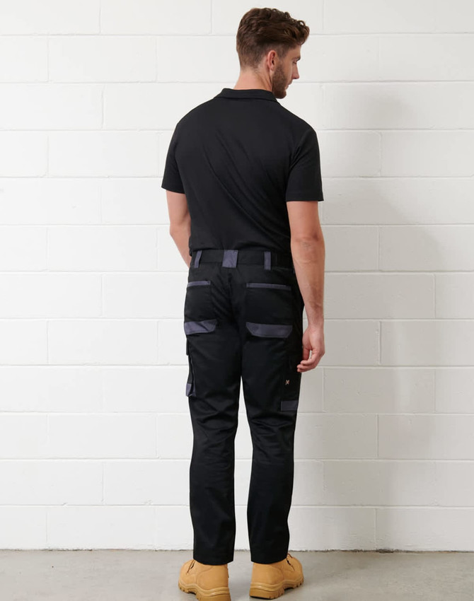 A black short-sleeve polo shirt with a logo, paired with black work pants and worn with tan boots.