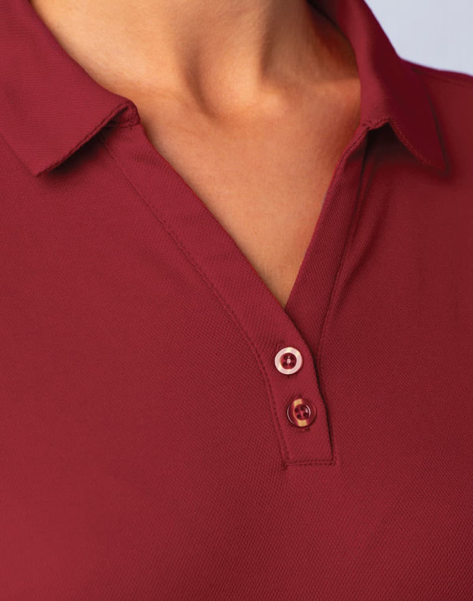 A close-up of a burgundy short sleeve polo shirt, featuring a classic collar and buttons. The shirt has a logo.