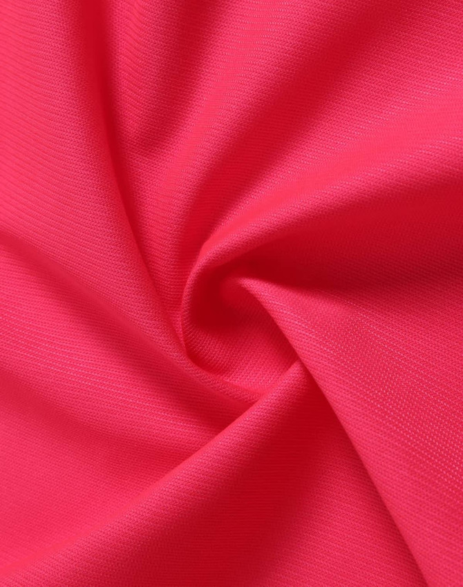A swirl of bright pink fabric, showcasing a textured surface ideal for safety apparel.