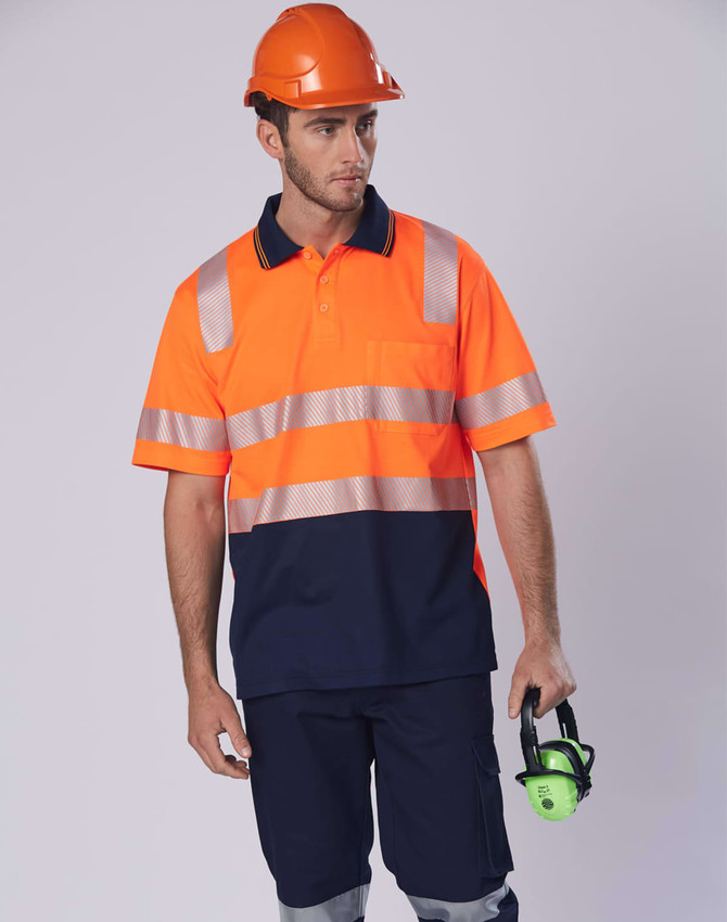An orange and navy work polo shirt with reflective stripes, worn by a man holding hearing protection, against a neutral background.