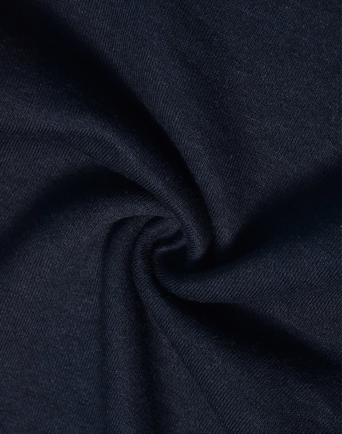 A close-up of dark navy fabric with a smooth, soft texture, showcasing a poly/cotton blend.