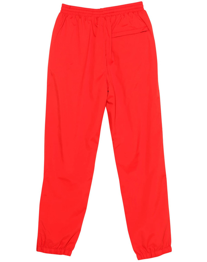 Red track pants with an elastic waistband and ankle cuffs, featuring a single pocket and a logo.