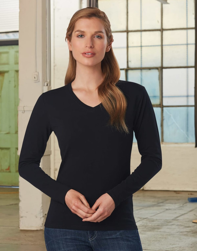 A black long-sleeve V-neck T-shirt on a model in an industrial setting. The shirt has a fitted design.