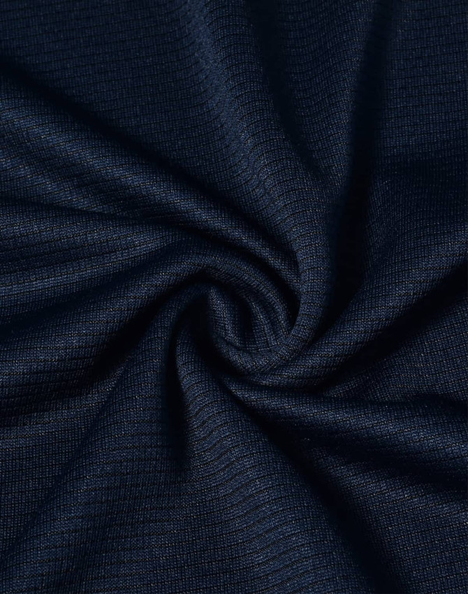 A close-up of navy blue textured fabric, displaying a smooth, lightweight weave. The fabric has a logo present.