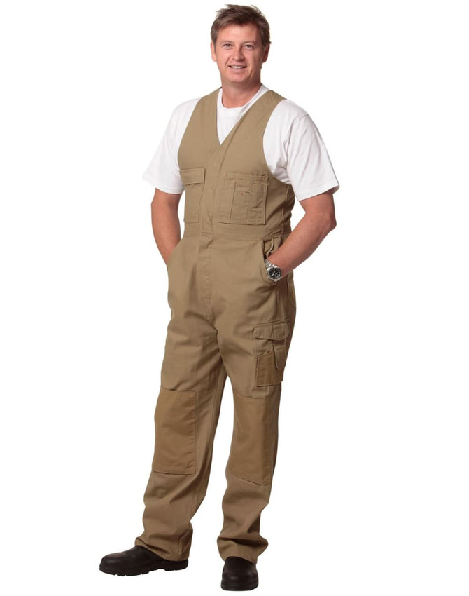 Men's DURA WEAR action back overalls in khaki, featuring multiple pockets and a logo, worn by a man.