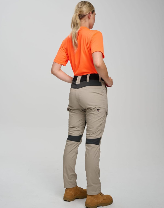 Work pants in light beige with grey accents, worn by a person in an orange shirt, facing away from the camera.