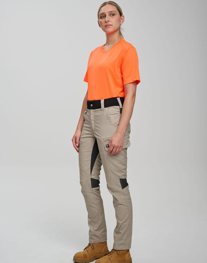 A model wearing orange workwear shirt and beige rip-stop poly/cotton stretch work pants with black detailing.