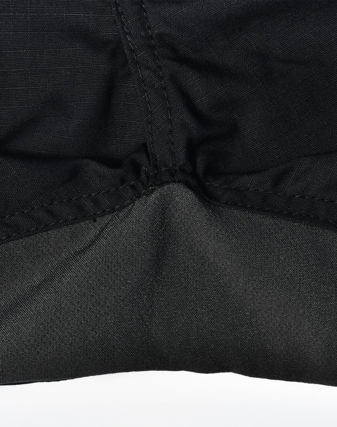 A close-up of black Rip-Stop Poly/Cotton Stretch Work Pants highlighting the fabric texture and stitching details.