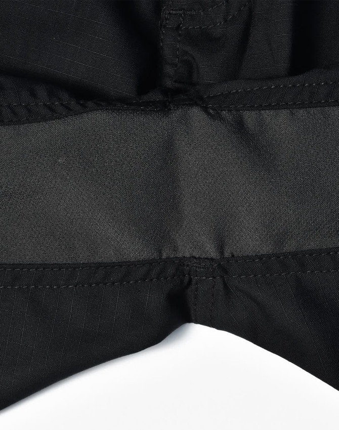 A close-up of black rip-stop poly/cotton stretch work shorts featuring a waistband detail. The shorts have a logo.