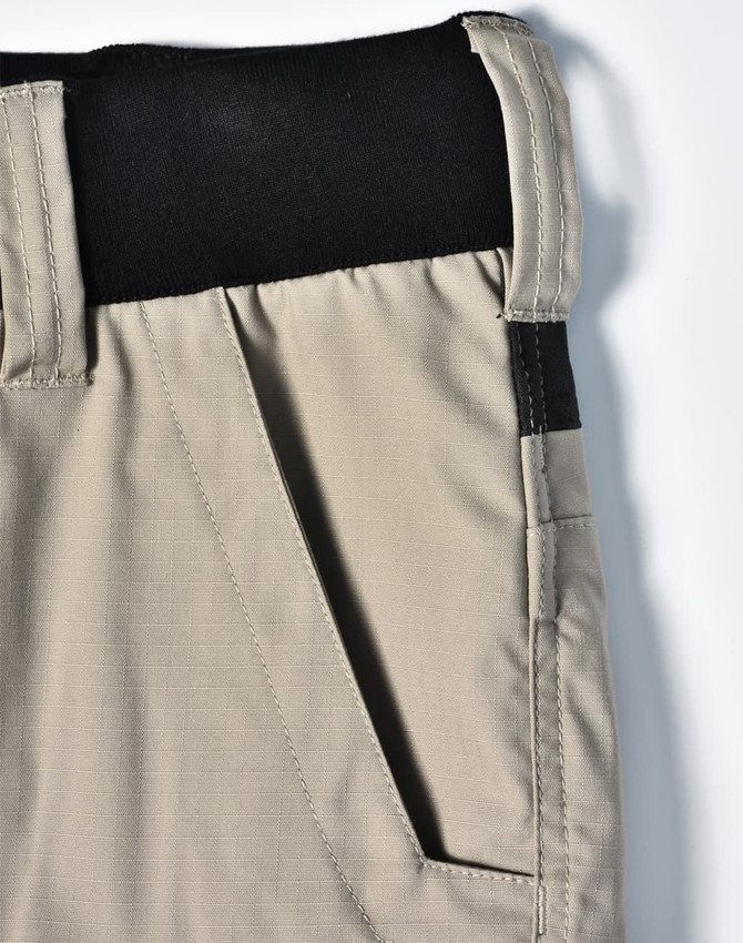 A pair of beige work shorts with a black waistband and pockets, featuring a logo on the side.