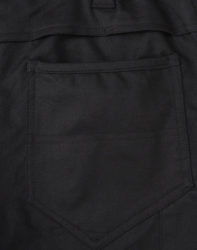 A close-up of black cotton stretch ripstop work pants, featuring a back pocket design and fabric texture.