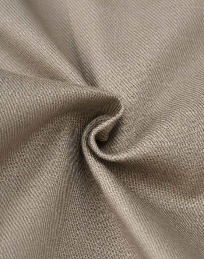 A close-up of beige cotton stretch ripstop fabric, showcasing its smooth texture and woven pattern.